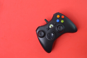 Top view of joystick game controller isolated on a red background.