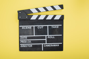 Fototapeta na wymiar top view of clapperboard on yellow, cinema concept