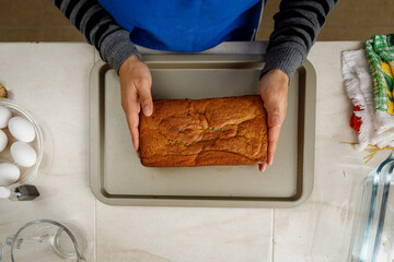 Mujer acomodando un panque recién horneado con sus manos. Concepto de repostería en casa