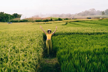 Overjoyed young tourist admiring beauty of green rice field