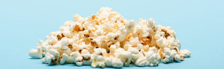 pile of tasty salty popcorn on blue, banner, cinema concept