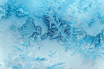 Ice patterns on frozen glass. Abstract ice pattern on winter glass as a background image. Copy, empty space for text