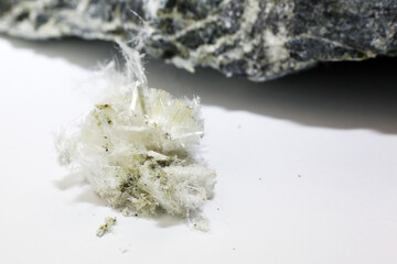 Chrysotile asbestos fibers lie in a heap on a white background. Macro photography.