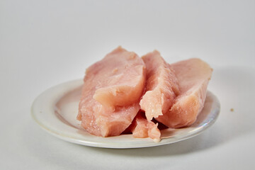 Pieces of Raw chicken meat on plate on white background