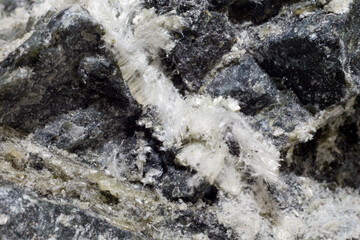 White fibers of asbestos mineral in stone, close-up.