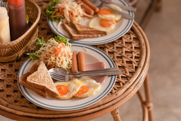 American breakfast, eggs, sausages and ham on wooden table