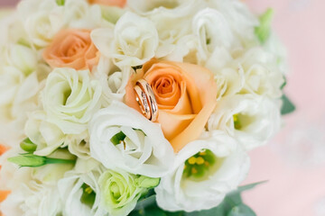 Wedding rings on the background of the bride's bouquet. Close-up. Soft focus.