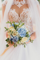 The bride holds a bouquet of flowers in her hands at the wedding, ceremony. Close-up.