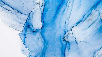 Naklejka premium Blue alcohol stains of paint with the addition of gold powder. Subtle waves of paint, abstract blue waves of the ocean, lines of marble. Liquid paints, gradient stains, painting.