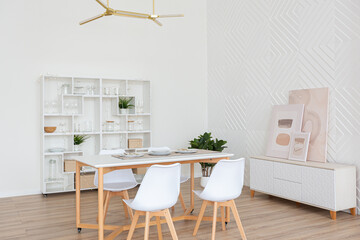 interior design spacious bright studio apartment in Scandinavian style and warm pastel white and beige colors. trendy furniture in the living area and modern details in the kitchen area.