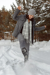 Girl Walking On The Snow With Boots, Young woman kicks snow with her foot on winter road in forest