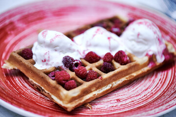 Waffeles with berries and ice cream on a wood background. toning. selective focus.