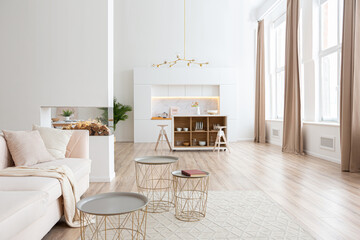 interior design spacious bright studio apartment in Scandinavian style and warm pastel white and beige colors. trendy furniture in the living area and modern details in the kitchen area.