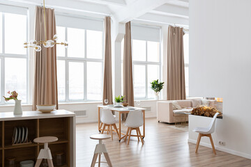 interior design spacious bright studio apartment in Scandinavian style and warm pastel white and beige colors. trendy furniture in the living area and modern details in the kitchen area.