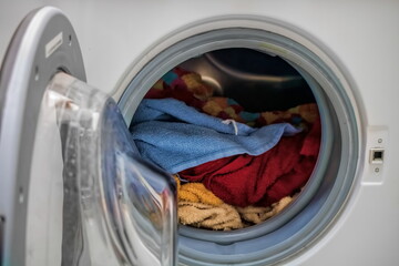 bullauge einer waschmaschine mit bunter wäsche