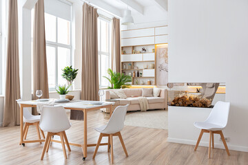 interior design spacious bright studio apartment in Scandinavian style and warm pastel white and beige colors. trendy furniture in the living area and modern details in the kitchen area.