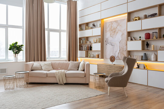 interior design spacious bright studio apartment in Scandinavian style and warm pastel white and beige colors. trendy furniture in the living area and modern details in the kitchen area.