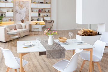 interior design spacious bright studio apartment in Scandinavian style and warm pastel white and beige colors. trendy furniture in the living area and modern details in the kitchen area.