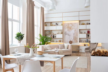 interior design spacious bright studio apartment in Scandinavian style and warm pastel white and beige colors. trendy furniture in the living area and modern details in the kitchen area.