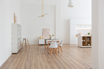 interior design spacious bright studio apartment in Scandinavian style and warm pastel white and beige colors. trendy furniture in the living area and modern details in the kitchen area.