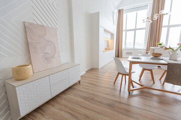 interior design spacious bright studio apartment in Scandinavian style and warm pastel white and beige colors. trendy furniture in the living area and modern details in the kitchen area.