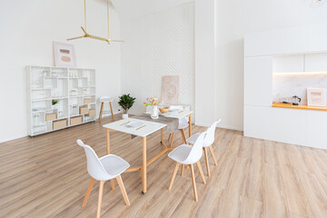 interior design spacious bright studio apartment in Scandinavian style and warm pastel white and beige colors. trendy furniture in the living area and modern details in the kitchen area.