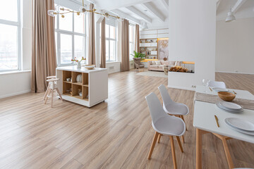 interior design spacious bright studio apartment in Scandinavian style and warm pastel white and beige colors. trendy furniture in the living area and modern details in the kitchen area.