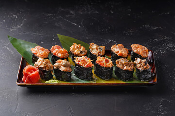 Set of Gunkan Maki Sushi with different types of fillings (salmon, scallop, eel, shrimp, crab, mussels) and caviar on black background. Sushi menu. Japanese food sushi set gunkan.