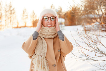 Cheerful girl in warm clothes walking outdoors near the beautiful forest