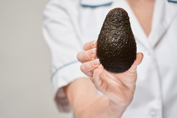 nutritionist doctor healthy lifestyle concept - holding organic avocado fruit