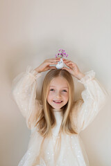 kid holding hands Cute Easter eggs with drawn faces and floral purple wreath