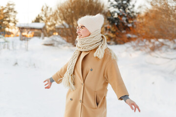 Cheerful girl in warm clothes walking outdoors near the beautiful forest