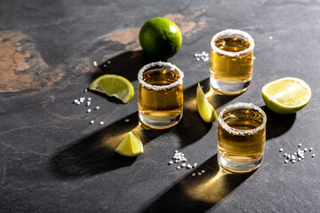 Tequila in a glass served with limes and salt. Mexican national drink