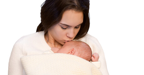 young mother kissing her sleeping newborn baby wrapped in blanket isolated