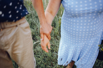 Elderly couple resting in nature and holds hands together. Focus on background