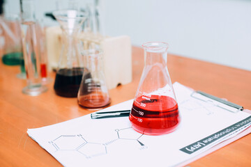 Red liquid on beaker with lab equipment on the table