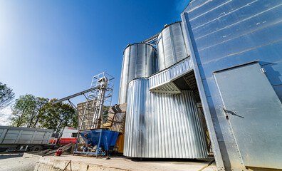 Enter to factory were dry grain kept. Steel constructions in front of factory. Crop storage in factory. Selective focus on steel constructions and technique. Closeup.
