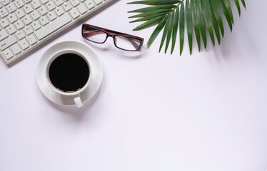Top view of coffee with other supplies and keyboard on white background and copy space for insert text.
