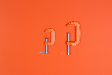 clamp, clamps on an orange background. compress, repair, construction.