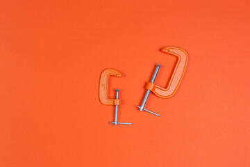 clamp, clamps on an orange background. compress, repair, construction.