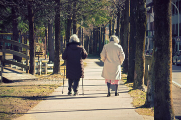 old women walking togheter outdoors, senior friends doing healty activity in a park