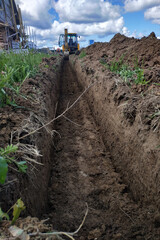 Wiring of an electric cable on the dug trench, supply of the electric power to the house on the...