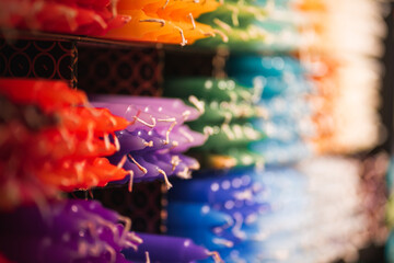Many different colored candles on a shelf