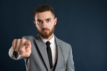 Serious young businessman pointing at you