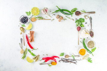 Fresh herbs, dried colorful spices. Cooking background flatlay with variety spices, herbs pepper, vanilla bean, cinnamon, basil, rosemary, chilli red green peppers, mint, parsley White table top view