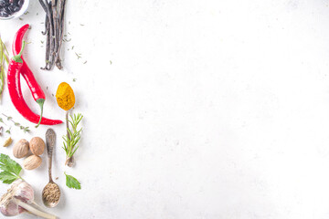 Fresh herbs, dried colorful spices. Cooking background flatlay with variety spices, herbs pepper, vanilla bean, cinnamon, basil, rosemary, chilli red green peppers, mint, parsley White table top view