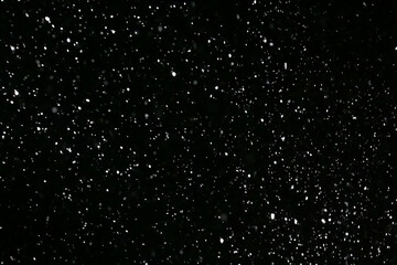 It snows at night in a ray of light.