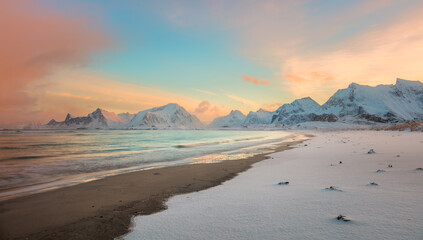 Panorama of Winter sunrise over the sea and mountains, colorful northern sunrise and sunlight in pink clouds.