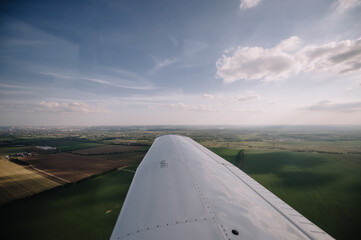 Fototapeta na wymiar view from the window of a small plane on the city and fields, landscape