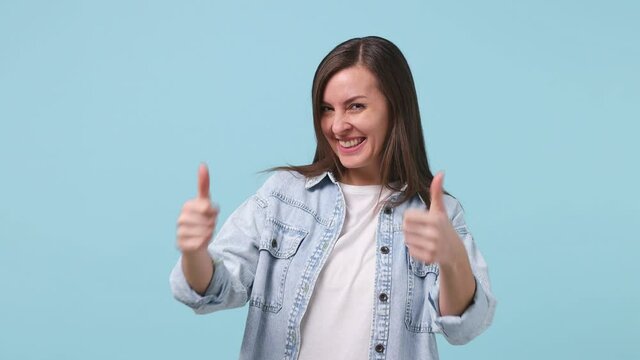 Confident beautiful long hair young woman 30s years old in denim jacket white t-shirt looking camera pointing fingers on herself showing thumb up like gesture isolated on pastel blue background studio